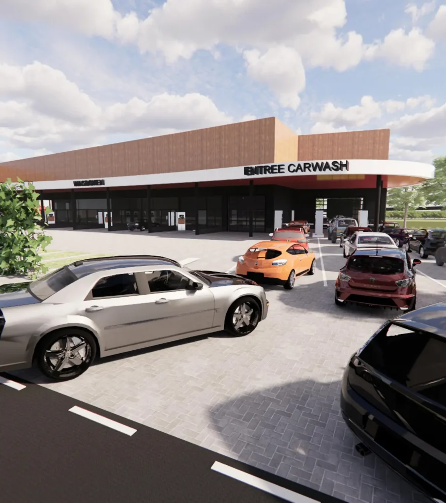 Een moderne carwash faciliteit met meerdere auto's die in de rij staan voor reiniging onder een deels bewolkte hemel.