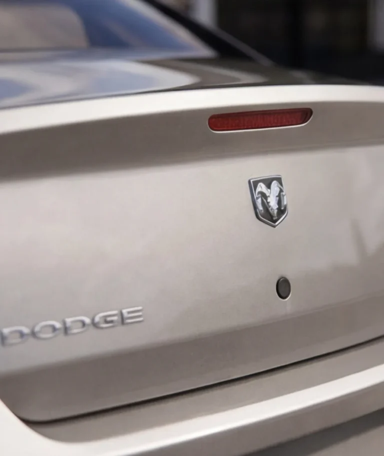 Achterkant van een zilverkleurige Dodge-auto met het merklogo zichtbaar.